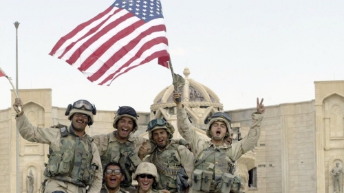 des-soldats-americains-brandissent-les-drapeaux-americain-et-irakien-devant-le-palais-al-faruq-a-tikrit-en-irak-le-14-avril-2003_6056816-2.jpg